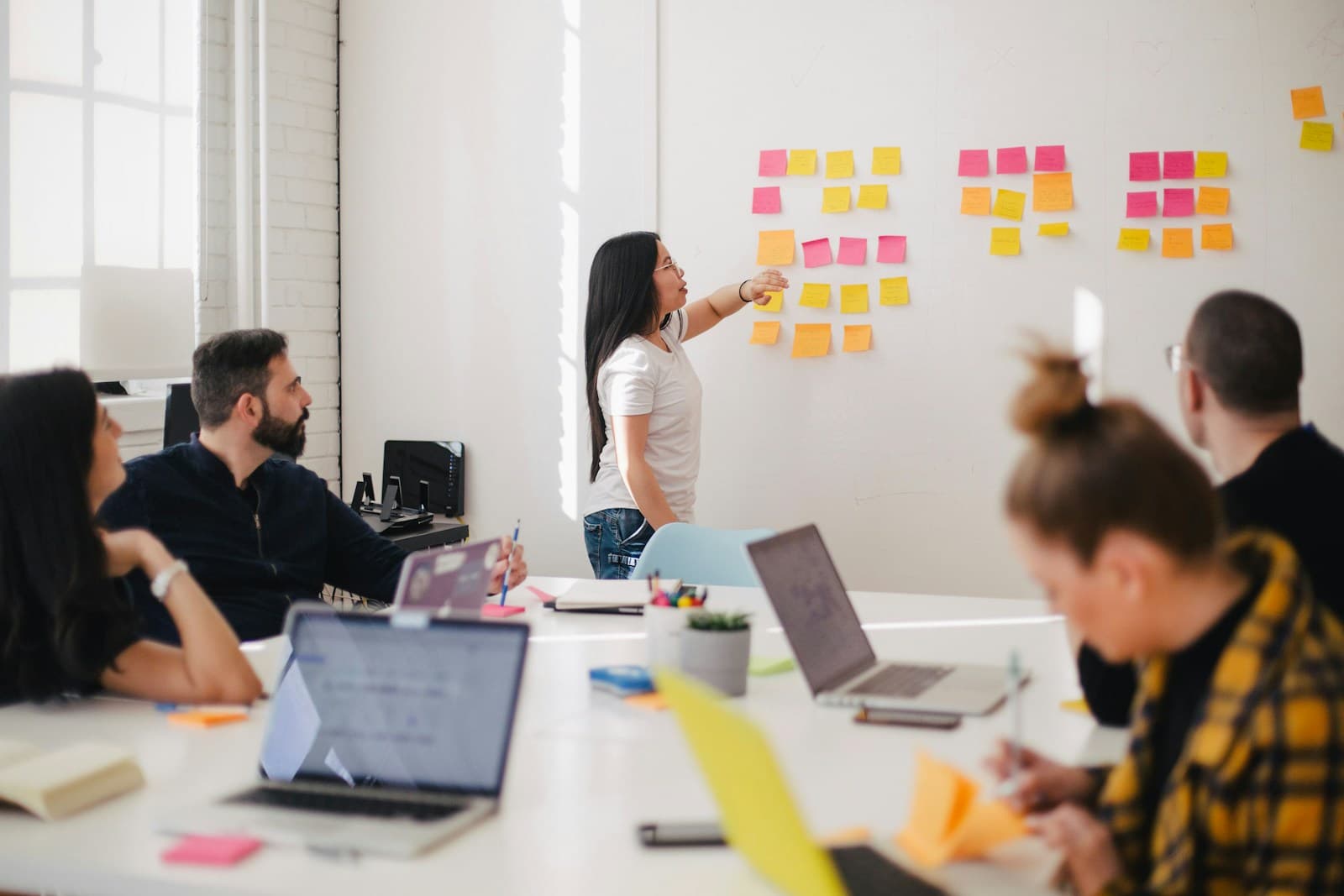 Apprenants en formation mobile autour d'une table avec ordinateurs